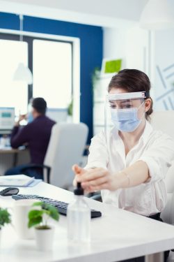 office-worker-following-safety-precaution-global-pandemic-with-coronavirus-applying-sanitizer-businesswoman-new-normal-workplace-disinfecting-while-colleagues-working-background_482257-9842 office-worker-following-safety-precaution-global-pandemic-with-coronavirus-applying-sanitizer-businesswoman-new-normal-workplace-disinfecting-while-colleagues-working-background_482257-9842